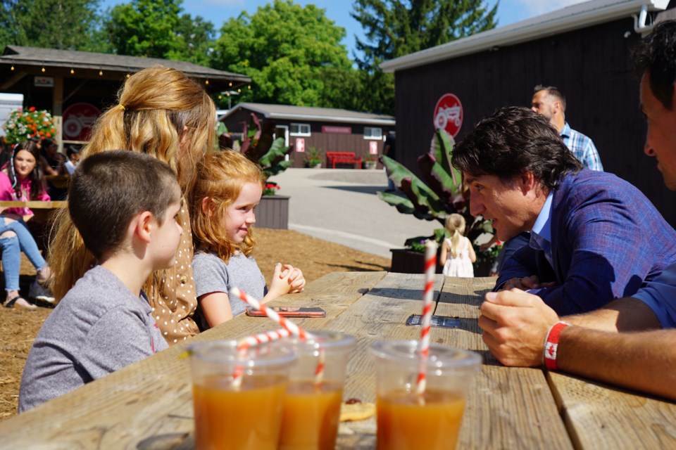 Nursing aid Carly Whitman, PM Justin Trudeau and MP Adam van Koeverden speak about affordable child care at Springridge Farm Monday morning. 