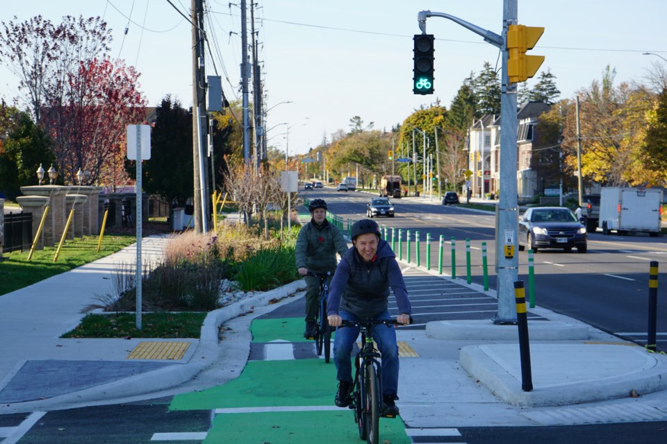 Councillors Rory Nisan (rear) and Kelvin Galbraith take an inaugural spin on the new bike lane on Plains Road Friday morning.