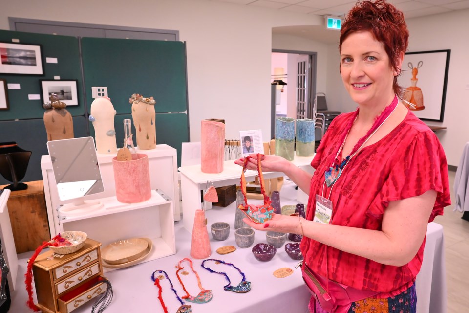 The Art Gallery of Burlington hosted the Arts Burlington spring sale of creative art this weekend. Christina Koli shows off a necklace of pottery at her table