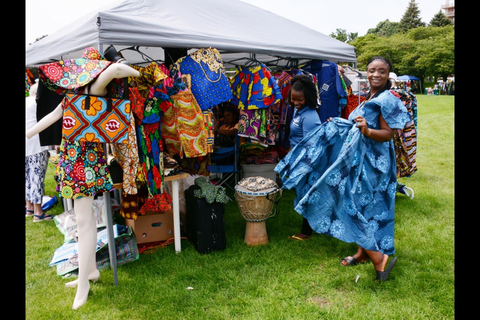 Lydia Neufville tries on a festive new dress at the Halton Freedom Celebration Festival in Spencer Smith Park Saturday.