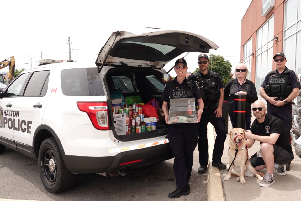 A Cram-A-Cruiser event was held Saturday at Longo's on Fairview Street that saw Halton Regional Police and Burlington Food Bank partner to collect items.  At the cruiser are (from left): Sarah Rudall, Dylan Danch, Kathleen Cox, George Macri, Andrew Needham and Journey, the Canine therapy dog.