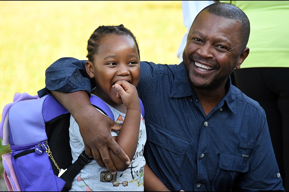 Walter Sashiri waits outside the classroom door with daughter Zippora on her first day of kindergarten at Confederation Park Elementary Wednesday. 