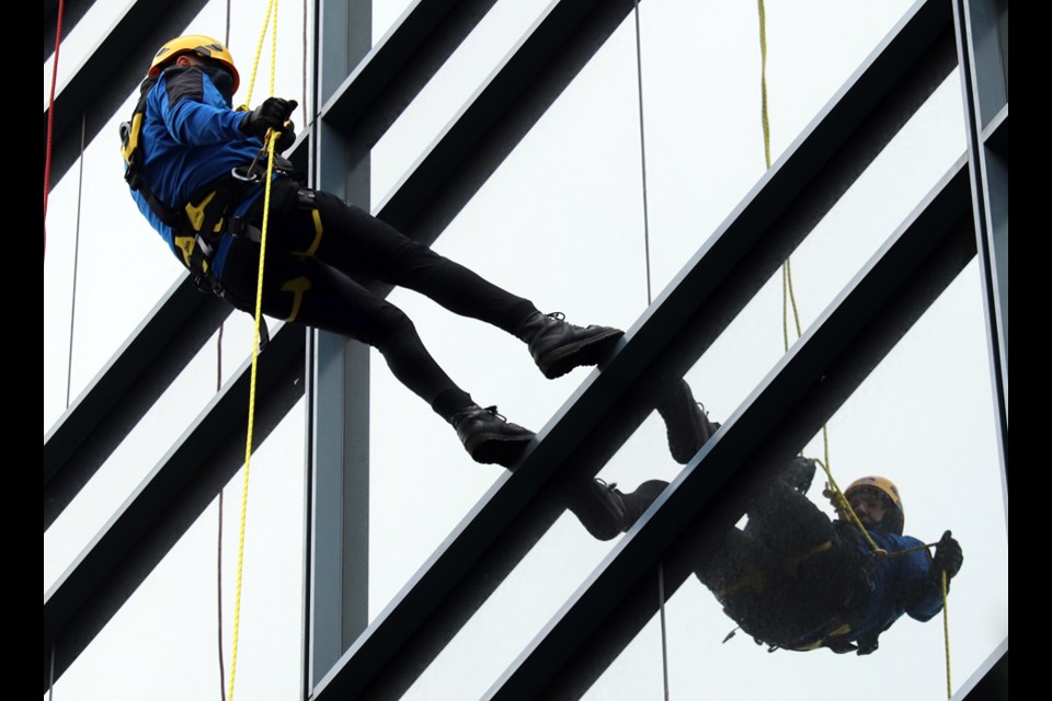 Burnaby Mayor Mike Hurley makes his way down 28 storeys during the Easter Seals Drop Zone fundraiser at Metrotower 1 Thursday morning.