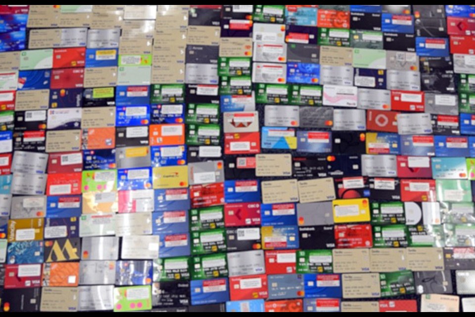 A police photo blurred to protect privacy shows debit and credit cards seized at a Burnaby residence during an RCMP search. 