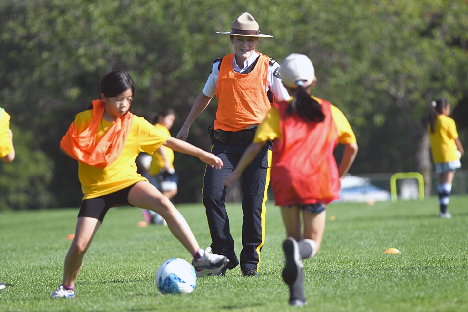 Insp. Peri Mainwaring joins in a scrimmage at the Burnaby RCMP's first all-girls soccer camp this week.