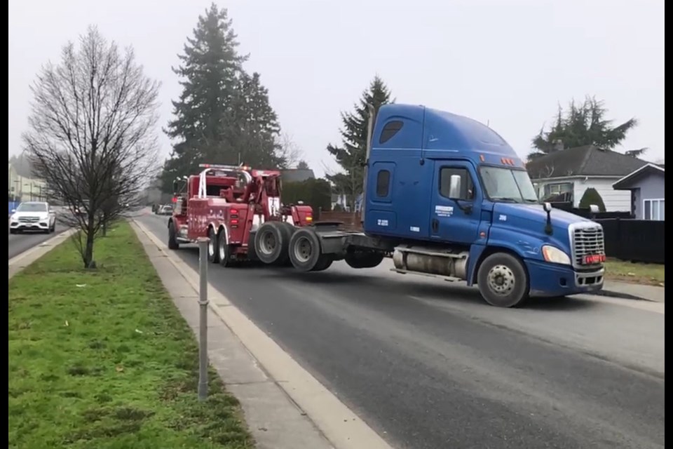 A semi is towed for safety violations on 10th Avenue on the Burnaby-New Westminster border Wednesday.