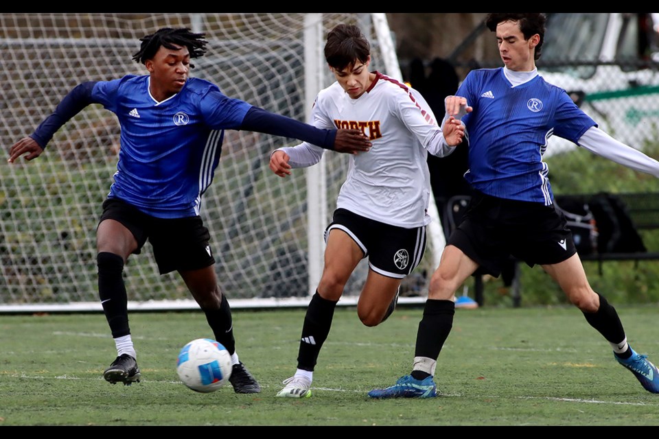 Burnaby North Vikings forward Alexandru Hodut splits a pair of Reynolds defenders in the first half of their final preliminary round match at the BC Boys AAA Provincial Soccer Championships, Friday at the Burnaby Lake Sports Complex West.