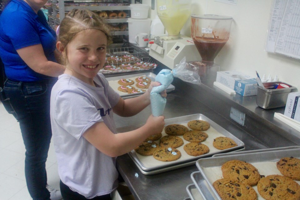 Natalie Kessler decorates Smile Cookies at a local Tim Hortons.