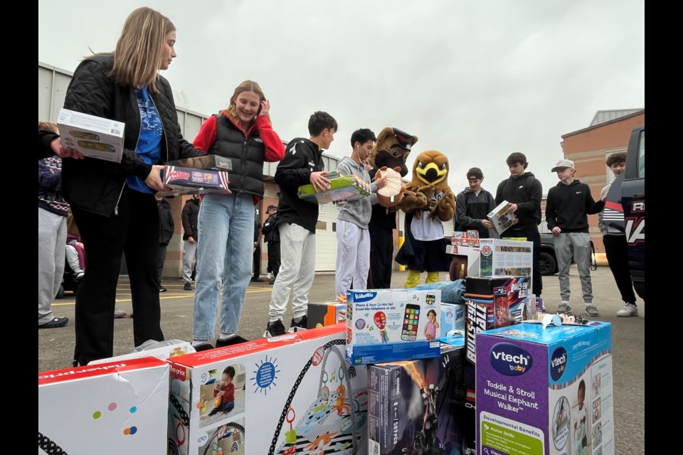 Students from Jacob Hespeler Secondary School pack a police car full of toys as part of their donation to the Waterloo Regional Police Service's stuff-a-cruiser campaign.