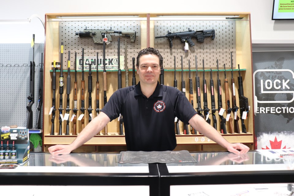 Ryan Simper stands behind the counter of Select Shooting Supplies in Cambridge 