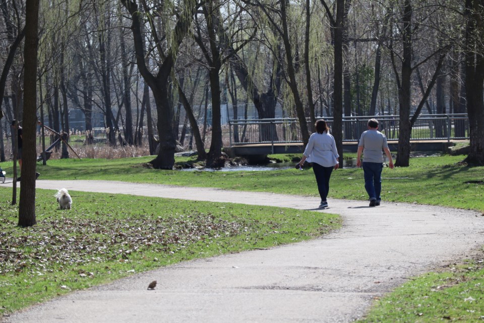 A couple walks their dog on the trail in Soper Park in an area that was once swampy farmland.