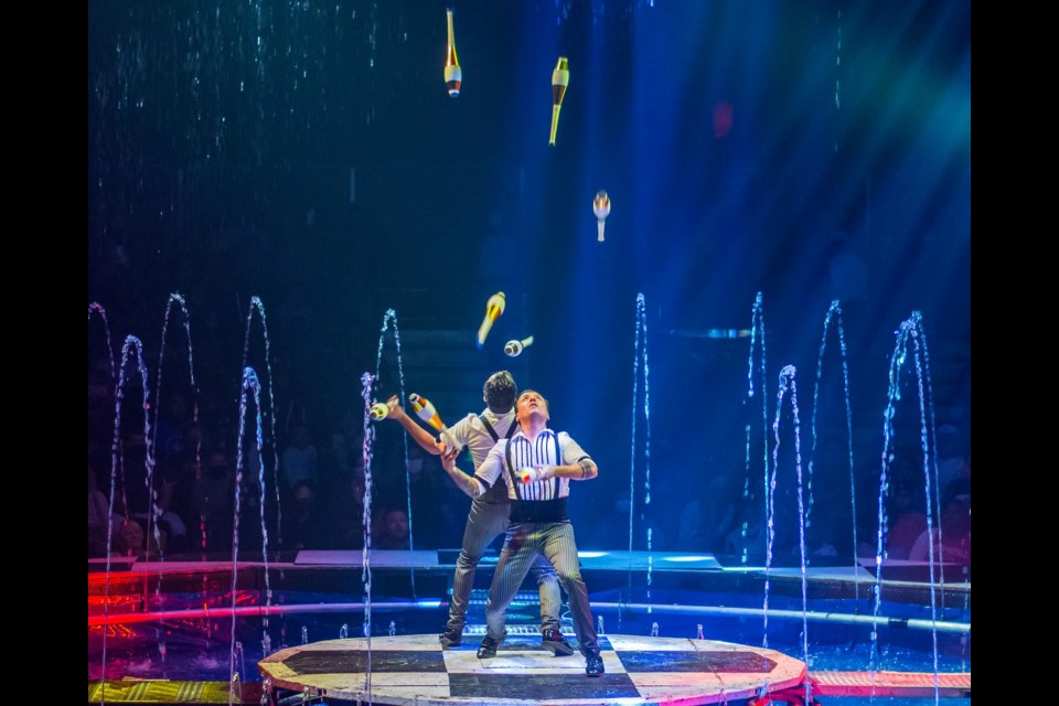 Jugglers spin on a moving floor surrounded by water