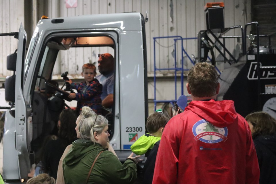 Families line up to get a chance to sit in a city vehicle.