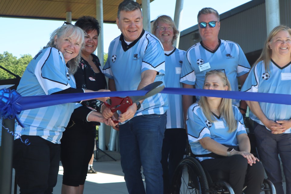 Cambridge mayor Jan Liggett (left), Six Nations chief Sherri-Lyn Hill, Toyota Motor Manufacturing Canada president Frank Voss (right) are seen with Cambridge city councilors cutting the ribbon at the opening of the new Cambridge Soccer Complex on June 15, 2024.