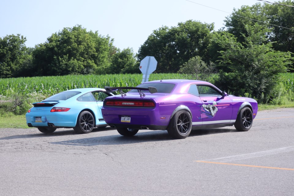 The Porsche and Dodge Challenger race down Black Bridge Road for the filming of Motorheads on Amazon Prime