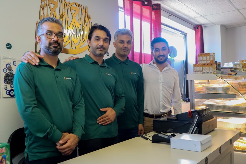 Abdi brothers Abdul Aziz Abdi (left) Abdul Karim Abdi, Abdul Munir Abdi and Hameed Abdi (right) stand behind their counter.