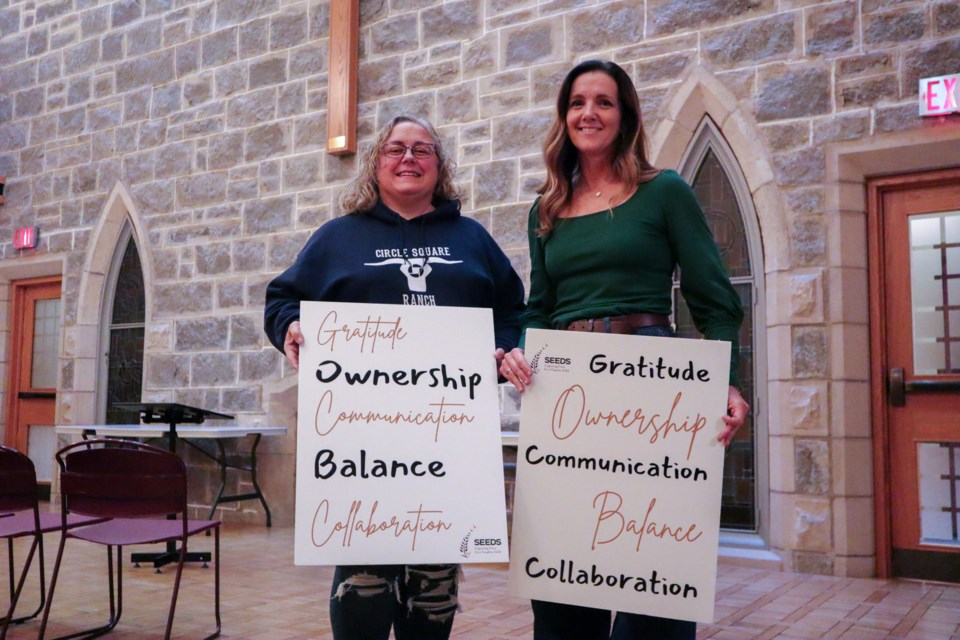 SEEDS program director Shelley Martindale (left) and SEEDS founder Laura Ross (right) hold their mission statement 