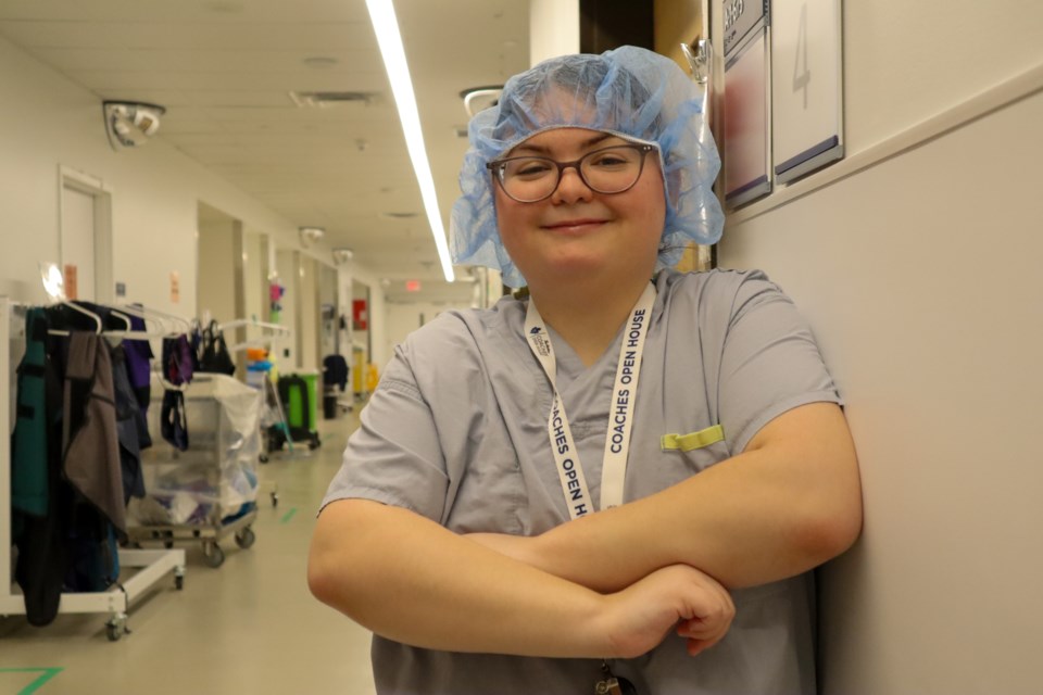 Marina Pereira stands in her scrubs in the hallway of the operating room.