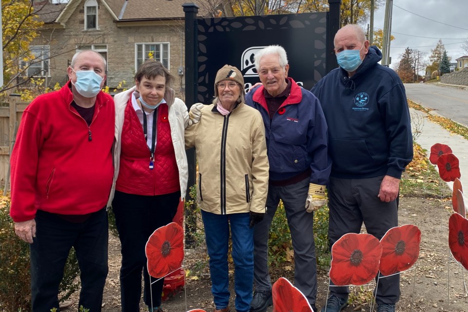 Residents of Season Cambridge stand in the retirement community's Poppy Garden Display.