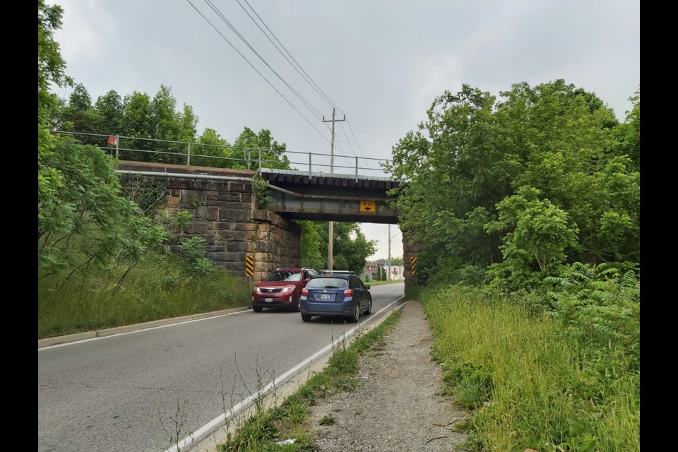 Two drivers slow down their cars to squeeze past one another as they go through Beverly Street underpass. 