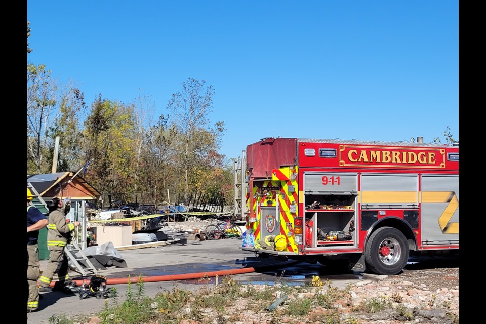 Fire crews remain on the scene Friday afternoon after a makeshift structure burned to the ground at the Dundas Street encampment off Samuelson Street.