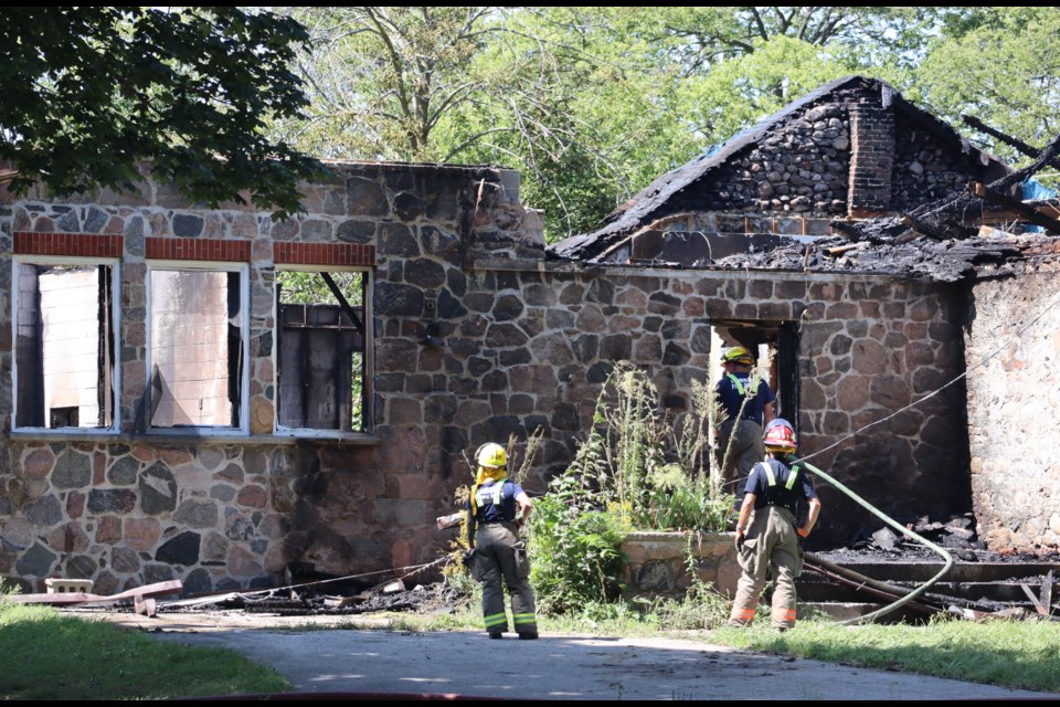 Cambridge firefighters put out hot spots the morning after fire gutted the 1870 heritage building that was once known as Riverbank School at 4800 Fountain Street in Cambridge. 