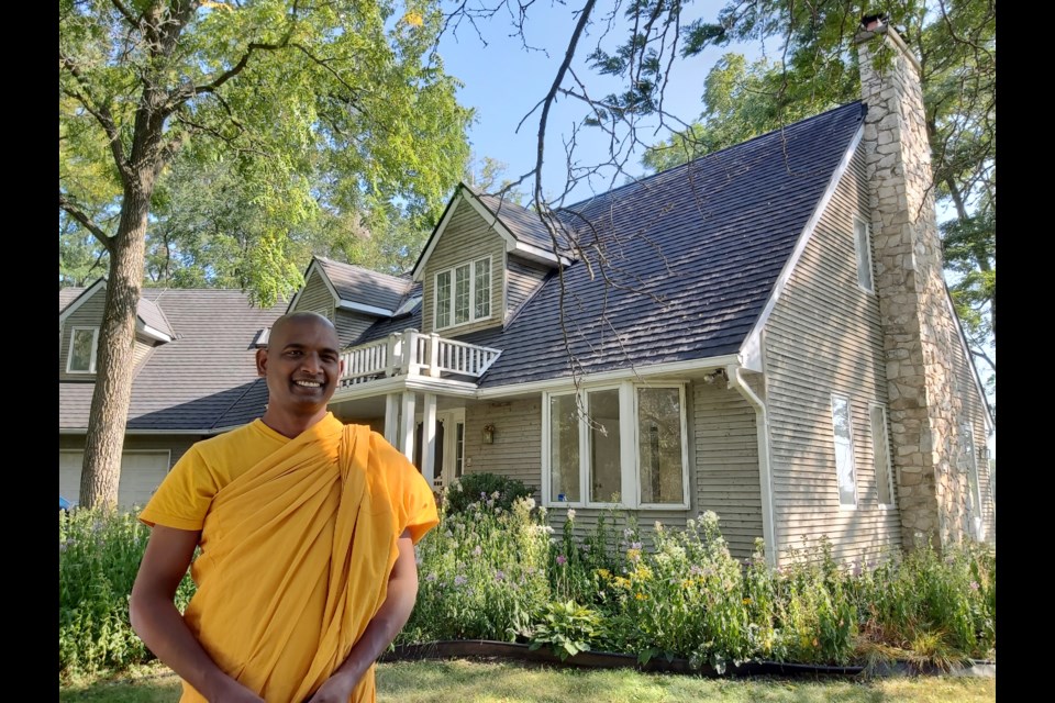 Horana Anuruddha Thero, reverend with a Cambridge Buddhist monastery, is pictured in front of the house part of the Barrie's Lake property.  
