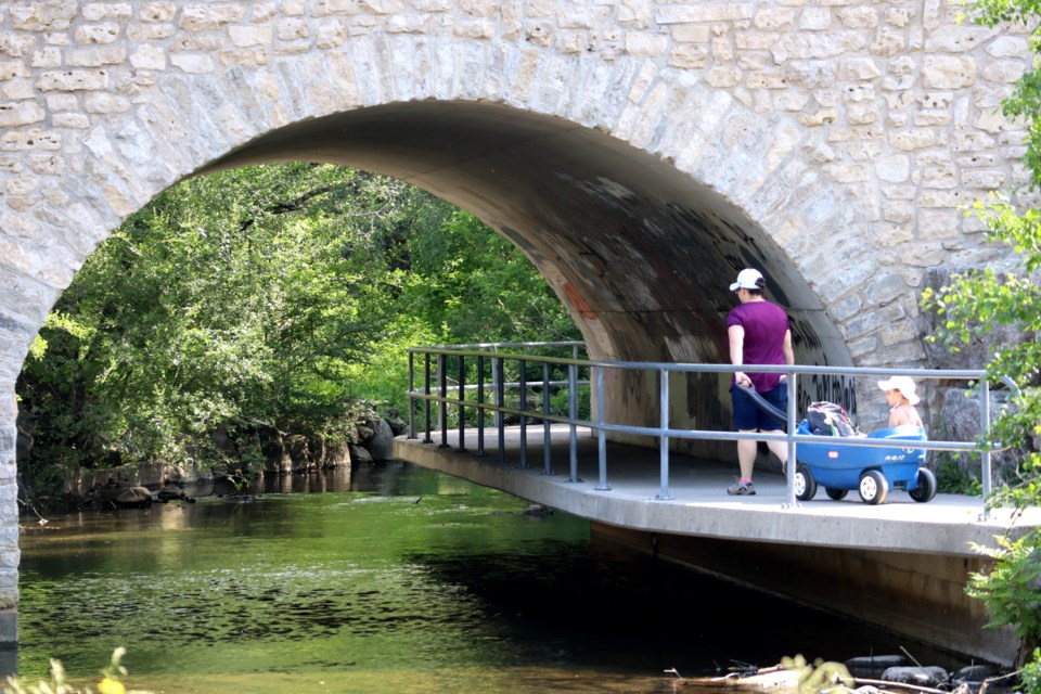 Going for a stroll under the historic Mill Creek bridge in Soper Park on Saturday.