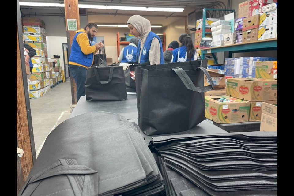 Volunteers with Islamic Relief Canada prepare food hampers at the Cambridge Food Bank.