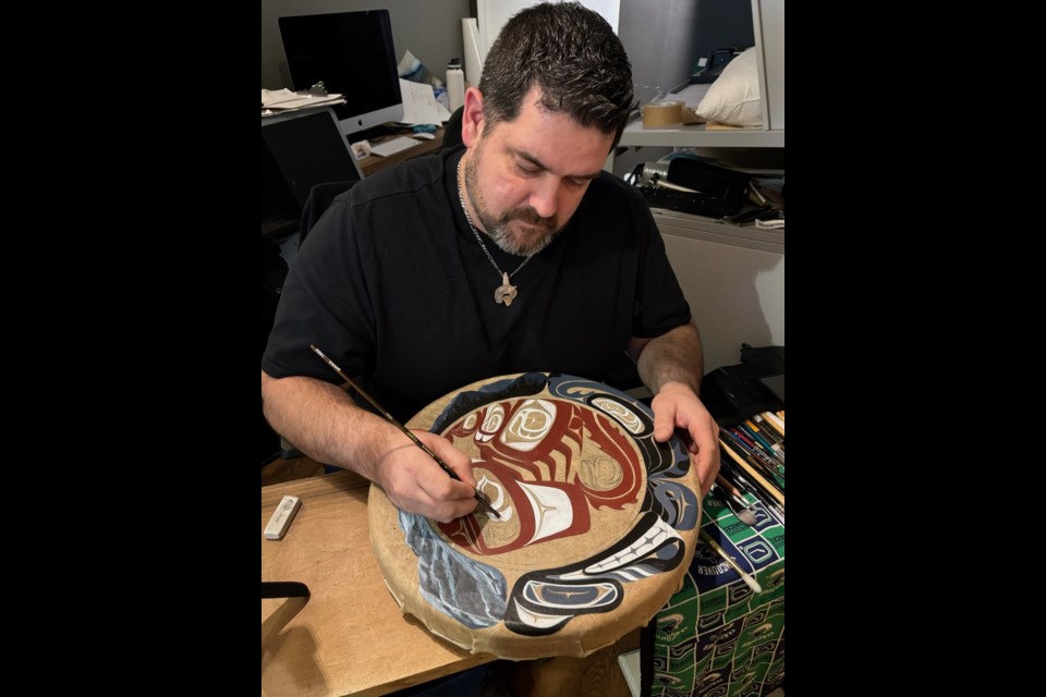 Levi paints traditional Northwest Coast forms on his personal drum.