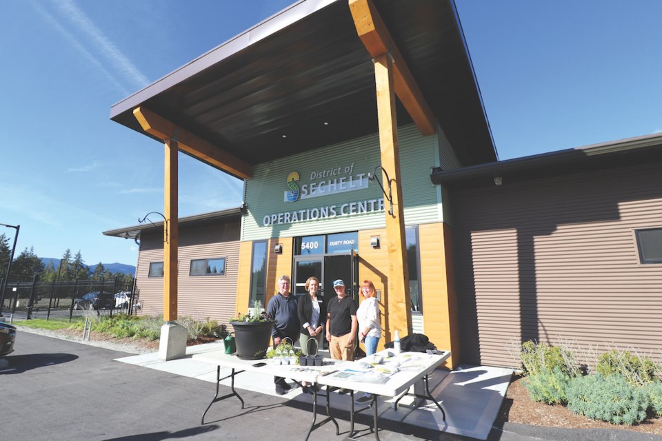 Sechelt Mayor John Henderson and staff Siobhan Smith and Michelle MacMorland as well as a visitor for the open house Oct. 12, Sukoshi Fahey. During the open house, MacMorland was giving planter demonstrations (foreground).