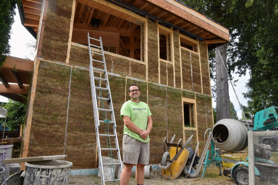 Packing walls with straw-clay, Tim Vigneux of Natural Focus said their goal is to build as ecologically ethically as they can.