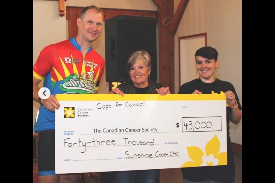 Sunshine Coast RCMP participant in Cops for Cancer, Cst. Mark Wiebe (left), accepts a cheque for $43,000 on behalf of the Canadian Cancer Society as this year’s Tour de Coast riders passed through Sechelt on Sept. 17. 