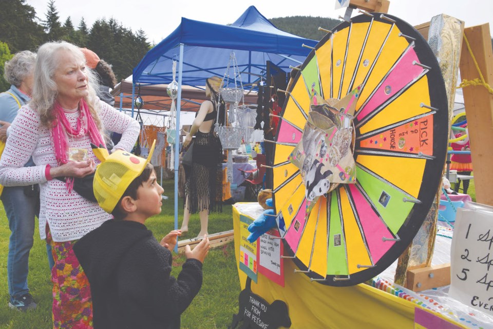 Keyon takes a spin of the prize wheel with volunteer Gloria supervising.

