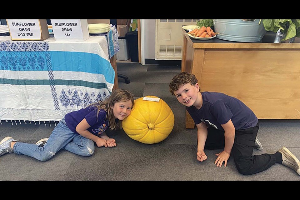 Ella and Hunter Duncan with the pumpkin they brought to exhibit from their garden.