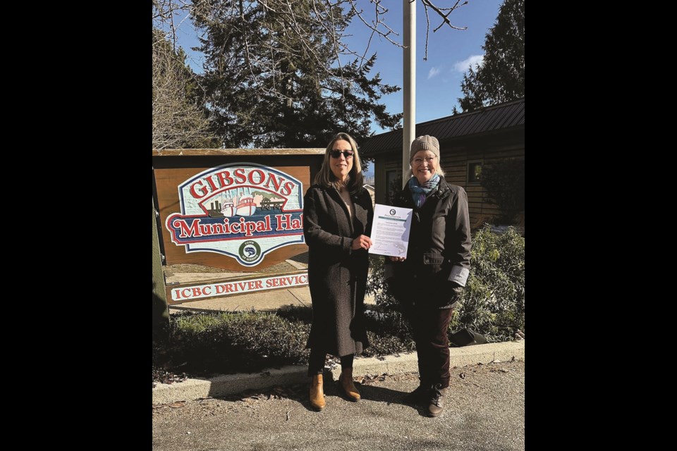  Toastmaster Johanna Rzepa receives the Toastmasters proclamation from Gibsons councillor Annemarie De Andrade.