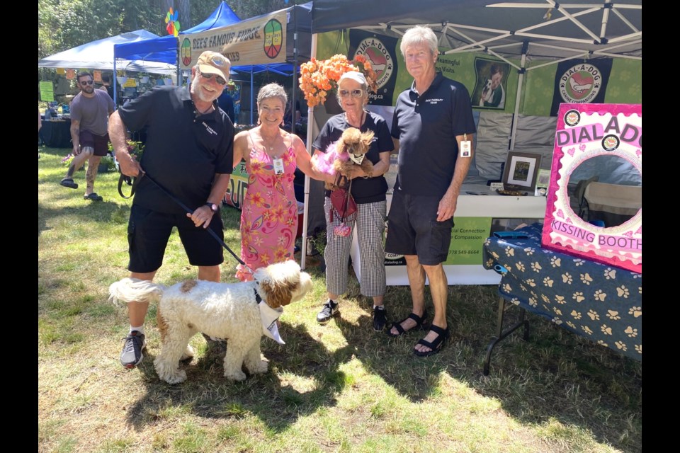 (L-R) Chuck Bertrand with 'Aussie,' founder Heather Fowler, Val Bissett with 'Daisy,' and Rob Haneck of Dial-A-Dog at the Halfmoon Bay fair on July 14. 