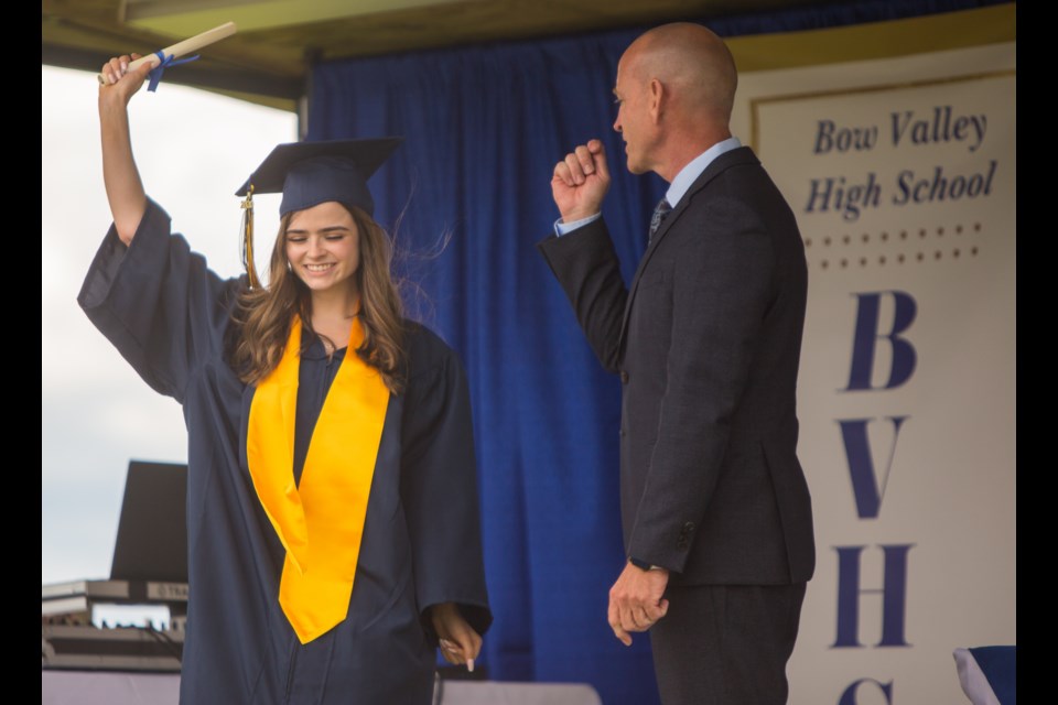 Bow Valley High School student Olivia Gill receives her diploma from mayor Jeff Genung  at her graduation at Spring Hill RV Park on Saturday (June 20). (Chelsea Kemp/The Cochrane Eagle)