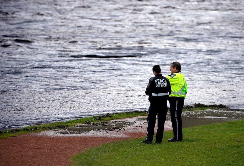 Cochrane Peace officers look over the rising Bow River during the 2013 flood. (File Photo)