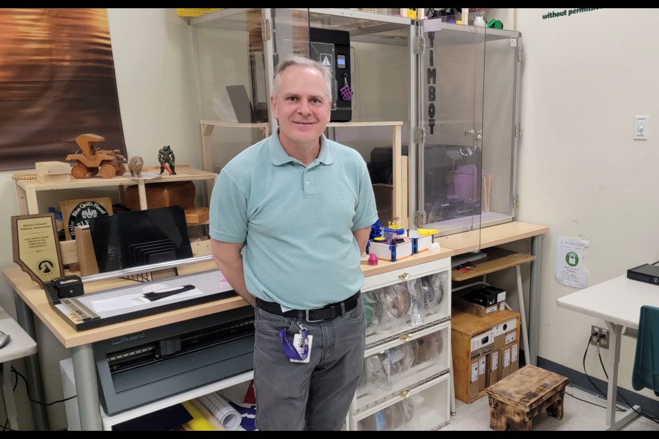 St. Timothy School career technology studies teacher, Jason Guenther, standing in front of the school's 3D printers dubbed the "Timbots," aimed to teach 3D design to students.