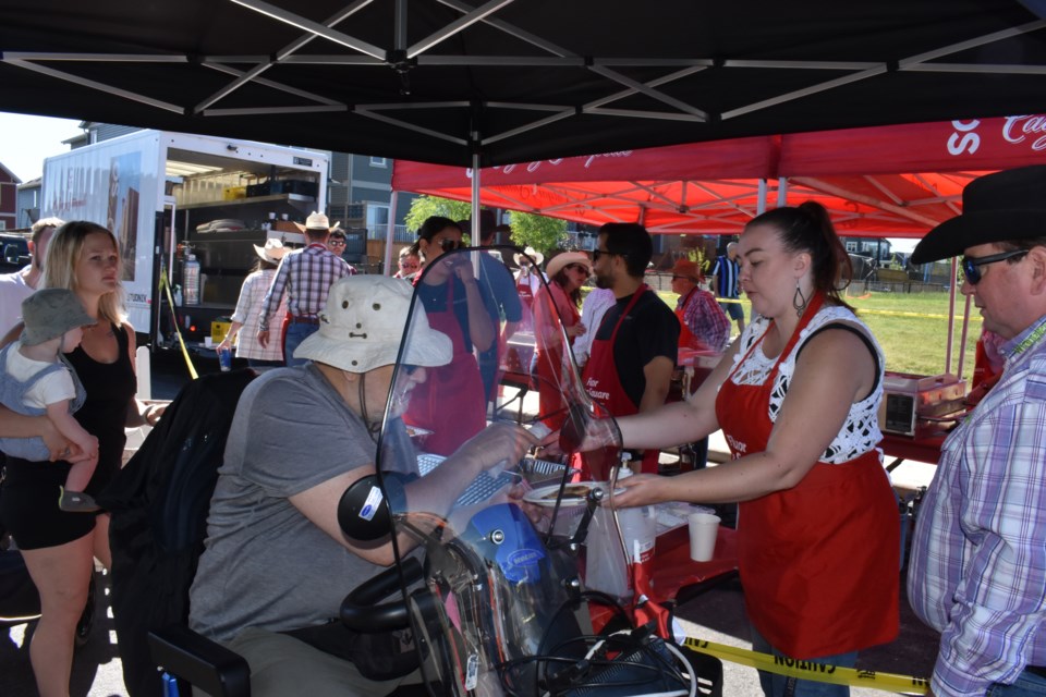 Workers handout pancakes and sausages to hungry mouths at the Fireside pancake breakfast 2024 in Northern Central Park