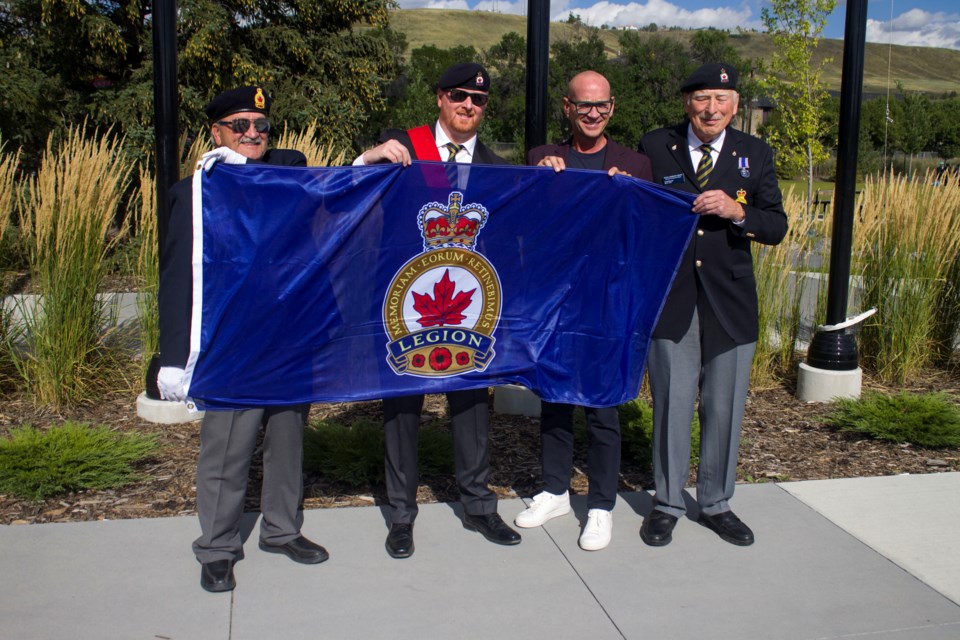 (From left to right) Cochrane Legion second vice president Eric George, sergeant-at-arms Joey Cyr, Jeff Genung, and former sergeant-at-arms Andy Bowyer holding the Canadian Legion Flag outside of The Station on Sept. 13.