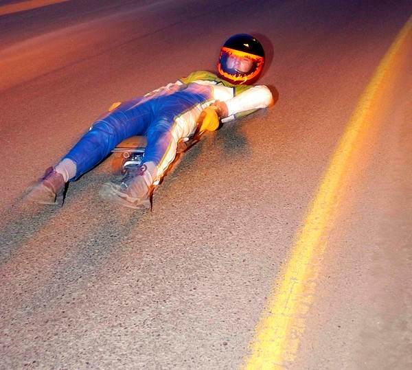 Ross Baradoy speeding along a road on a street luge.