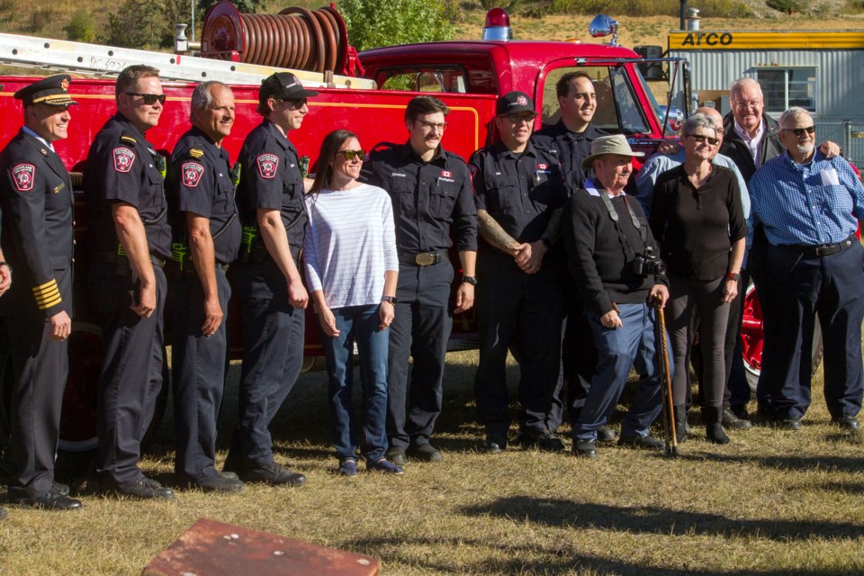 The 'Cochrane Firehall baby,' Kristi Perrault, poses with members from the Cochrane Fire Services during the 40-year reunion Saturday to commemorate the event.