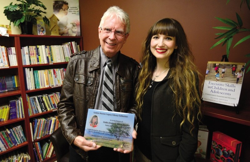 Terrance Haxton, left, and his daughter, Heather, marked the legacy of the late Lindsie Haxton, wife, mother, and philanthropist, by revealing a new section of resource books 