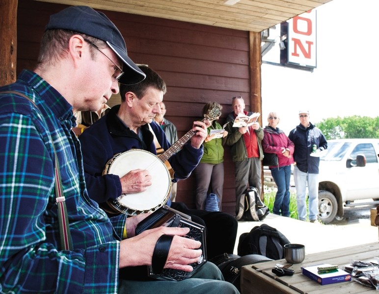 Greg Hooper plays his concertina in an impromptu jam session outside of the Water Valley Saloon along with banjo player Greg O&#8217;Neill.