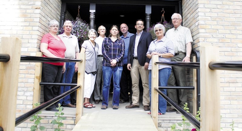 Members of the Cochrane Historical Archival Preservation Society (CHAPS) stand in front of the Davies Hospital (the Cochrane Historical Museum) located at the Cochrane Ranche 