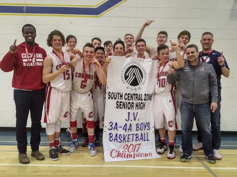 The Cochrane Cobras JV boys basketball team shows off their zones banner.