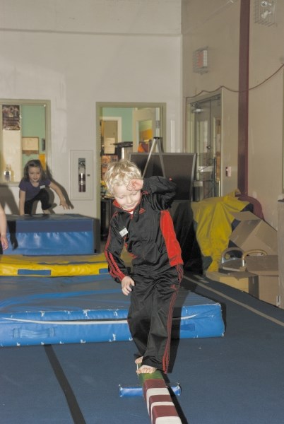 Zavier Boyd tackles a small balance beam during the Jan. 7 Kindergym session at the Cochrane Gymnastics Centre. At four years old, Boyd is a two-year-veteran of the