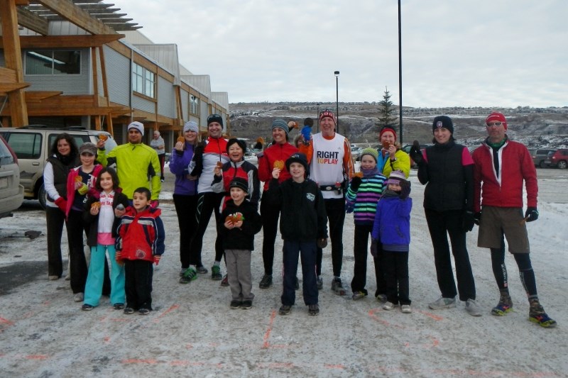 A group of runners, each holding a cookie from Pat&#8217;s Palette Pleasers, prepare for the final 2km lap along the Bow on the December 31st, 3rd Annual Marathon Quest 250